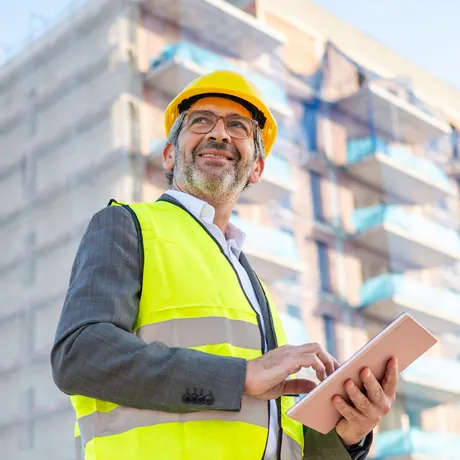 Expert bâtiment sur un chantier, tablette en main